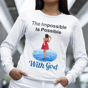 Long-sleeve Bella+Canvas t-shirt made from preshrunk ring-spun cotton with “Impossible Woman” design message, “The Impossible Is Possible with God,” inspirational apparel encouraging women to walk freely in God's incredible ways, woman in white long-sleeve t-shirt